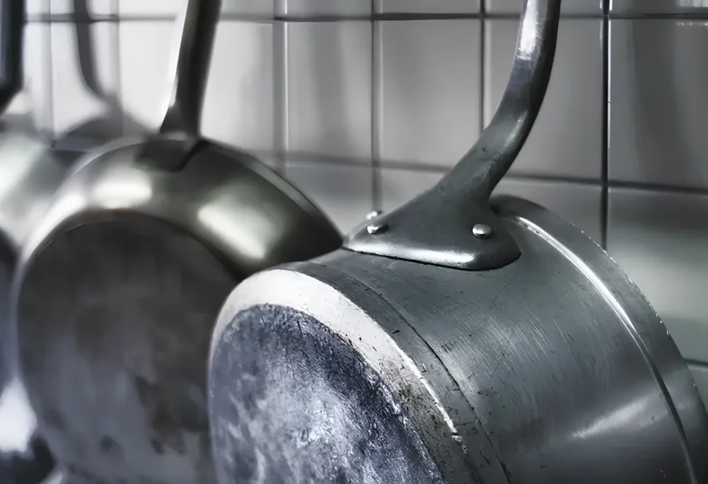 panelas de alumínio penduradas em uma parede.