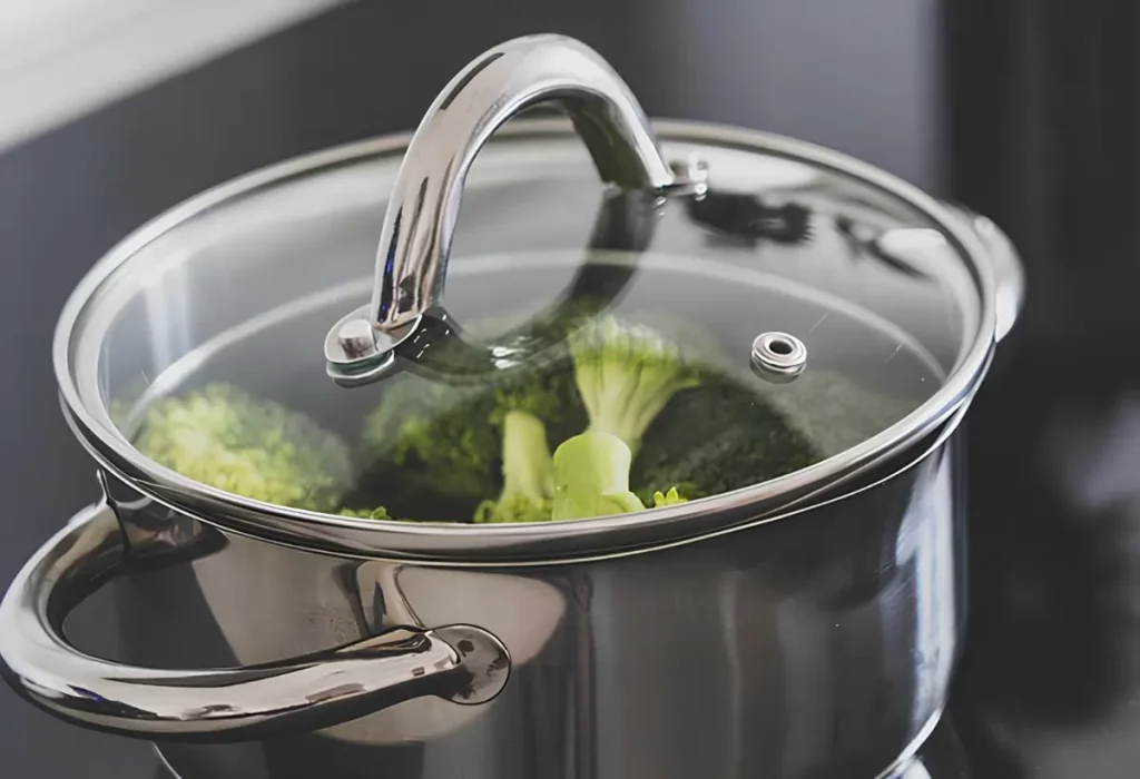 Uma panela de aço inox cozinhando brócolis.