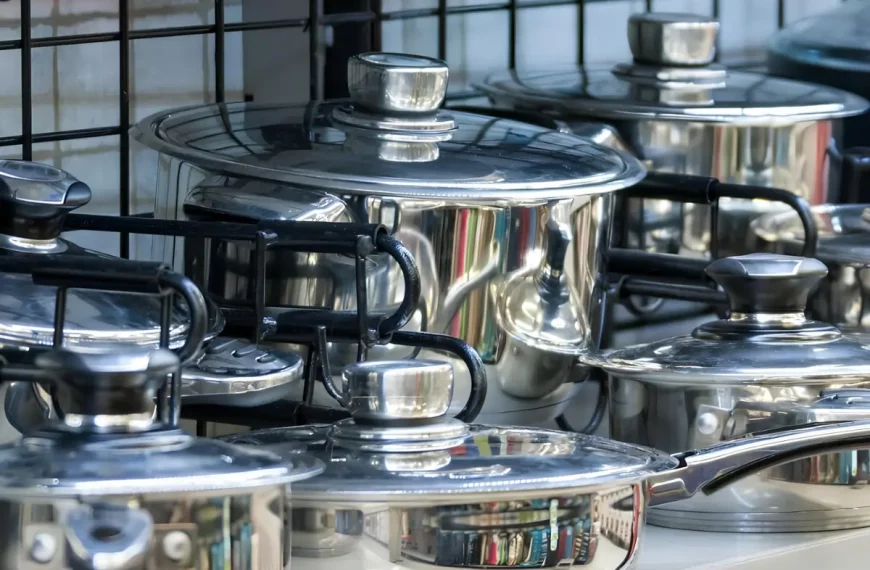 Jogo de panela de aço inox em cima de um fogão.