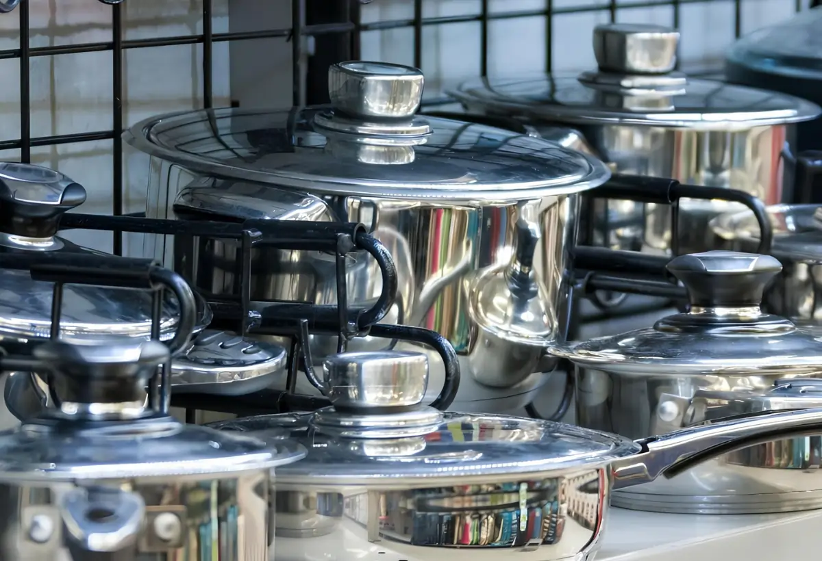 Jogo de panela de aço inox em cima de um fogão.