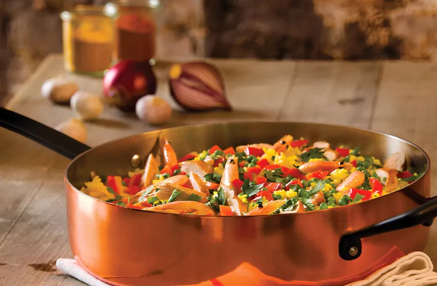 Uma panela de cobre em um fogão com comida dentro.