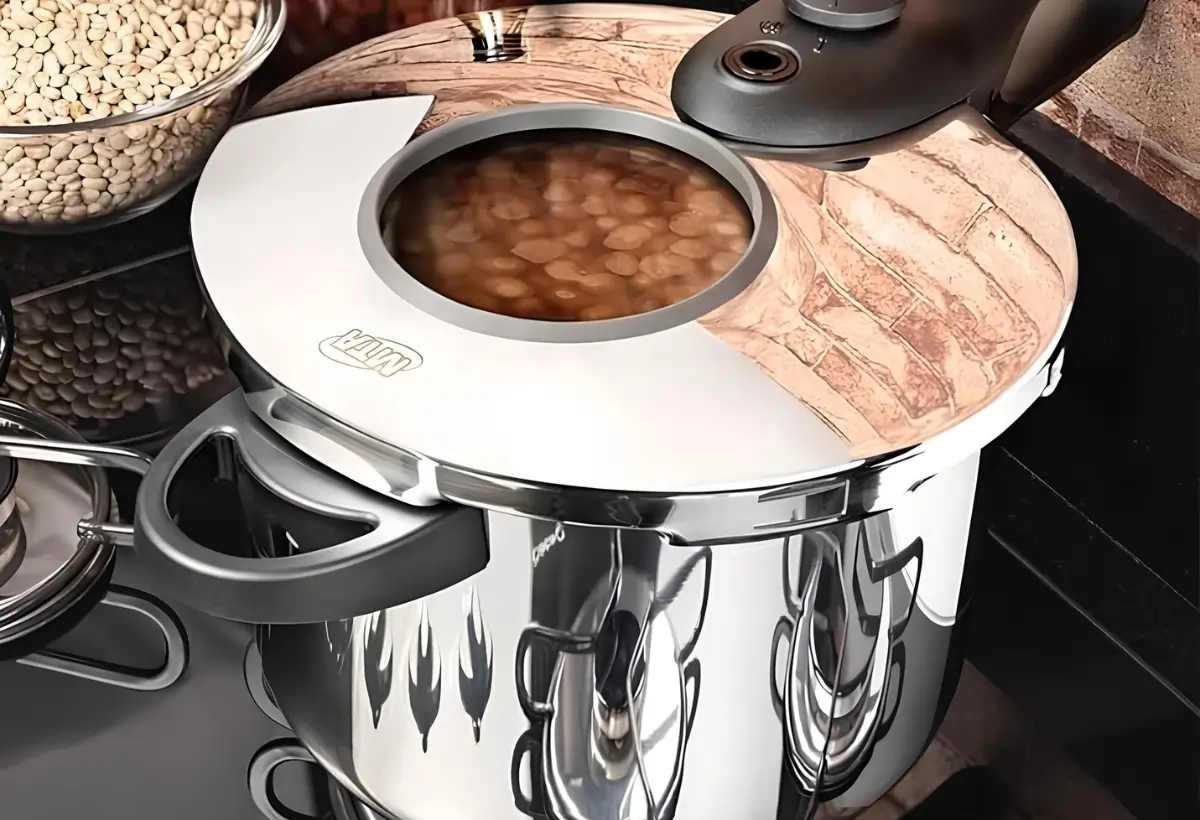 Uma panela de pressão de inox com feijão cozinhando.