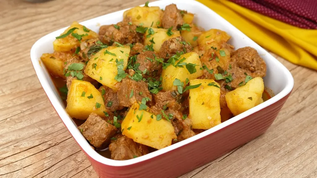 Uma travessa com carne e batata feito na panela de pressão pronto para ser servido.