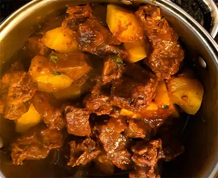 carne com batatas sendo feito na panela de pressão.