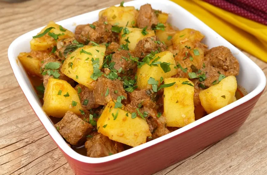 Uma travessa com carne e batata feito na panela de pressão.