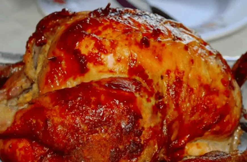 Um frango assado na panela de pressão em uma mesa pronto para ser servido.