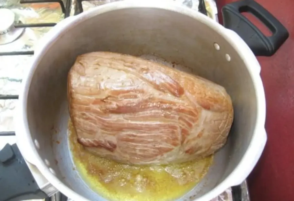 Uma carne de lagarto sendo feito na panela de pressão.