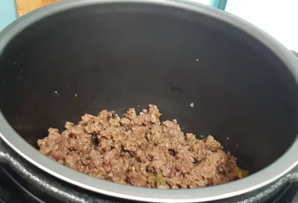 Carne moída sendo preparara na panela de pressão.