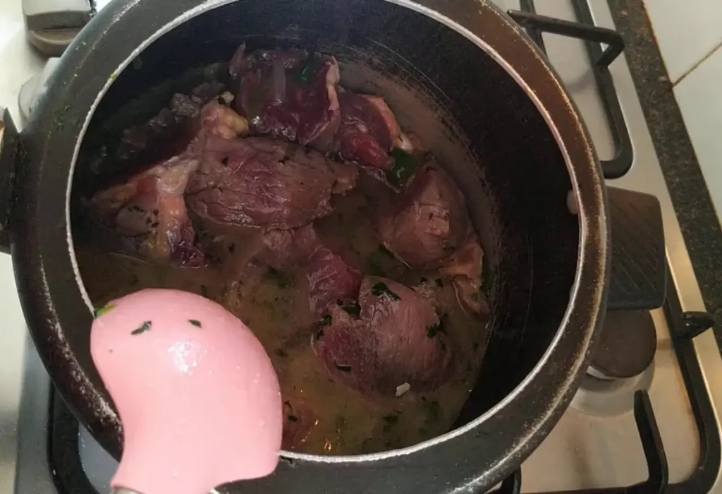 Uma panela de pressão com carne seca sendo preparada.