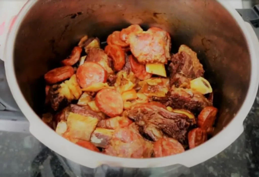Costela com linguiça sendo feitos na panela de pressão.