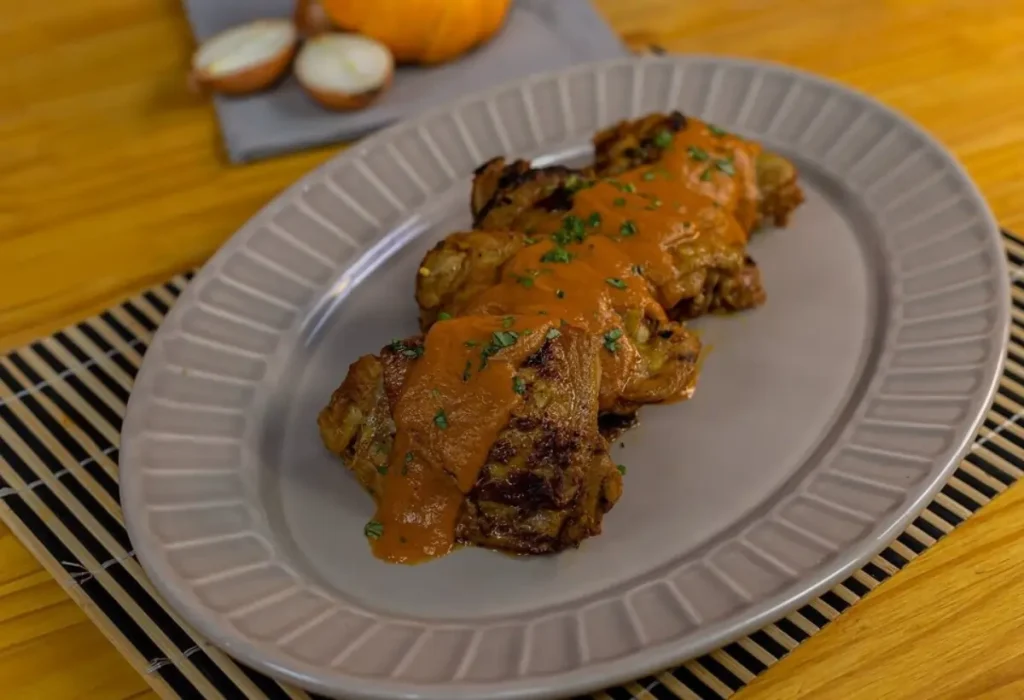 sobre coxa de frango feita na panela de pressão em um prato pronto para ser servido.