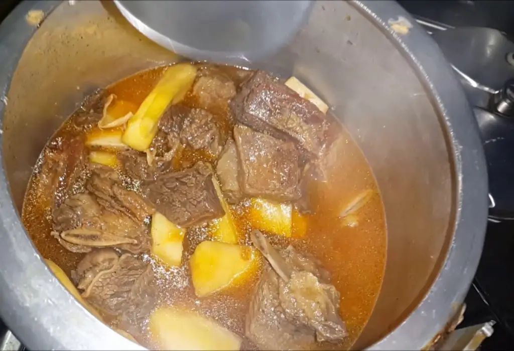 Vaca atolada sendo preparada na panela de pressão.