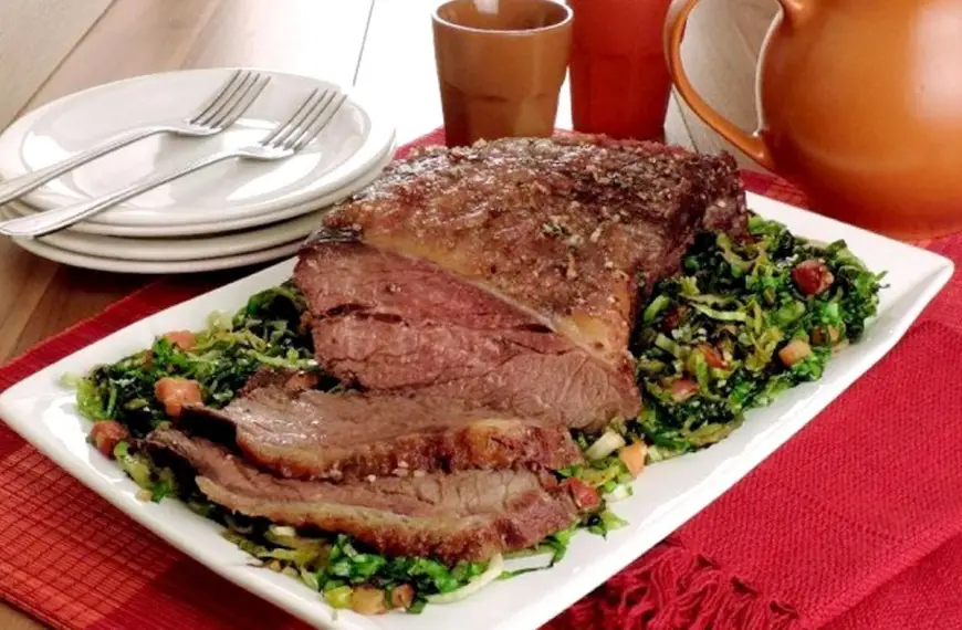 Um prato com carne de acém ao molho de ervas feito na panela de pressão em uma mesa pronto para ser servido.