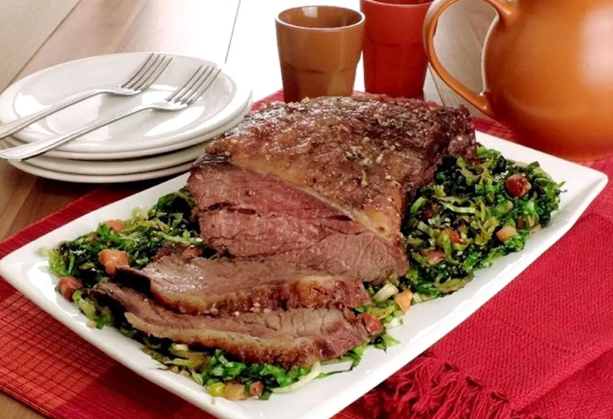 Um prato com carne de acém ao molho de ervas feito na panela de pressão em uma mesa pronto para ser servido.