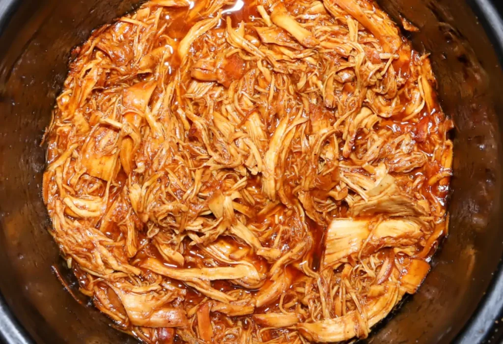 Frango desfiado sendo feito na panela de pressão.