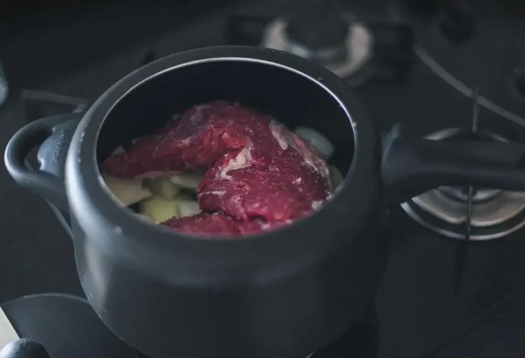 Carne de maminha na cerveja preta sendo preparada na panela de pressão.