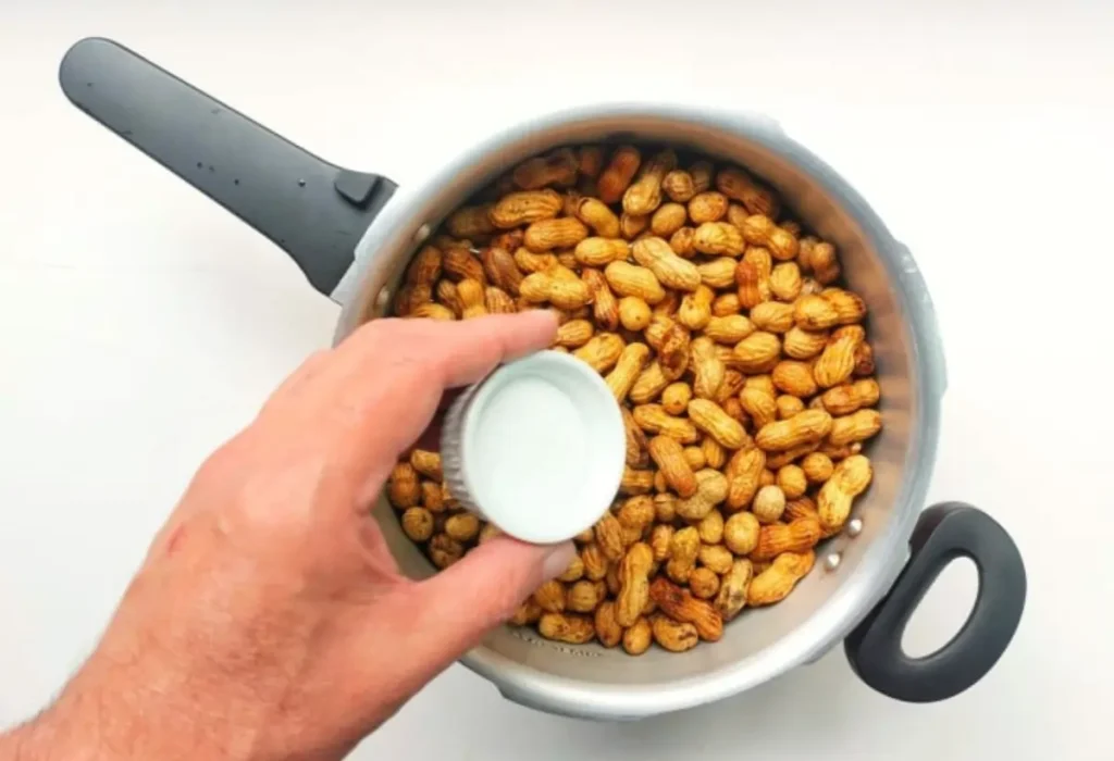 Amendoim com casca sendo preparados na panela de pressão.