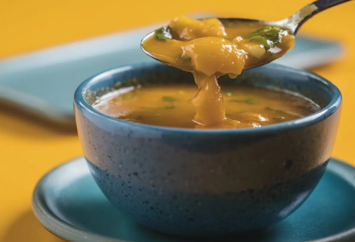 Uma tigela com caldo de mocotó pronto para ser servido.