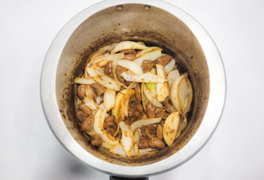 Coração de frango sendo preparado em uma panela de pressão.