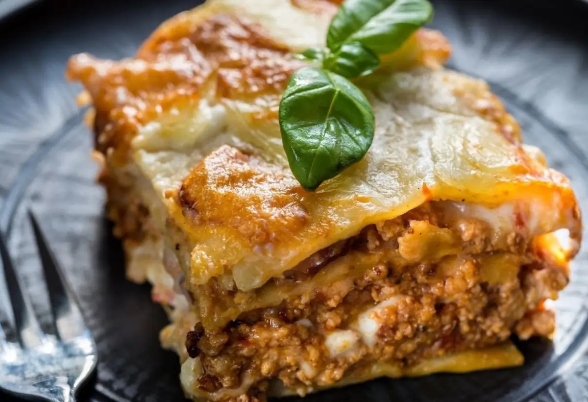 Uma prato com um pedaço de lasanha.
