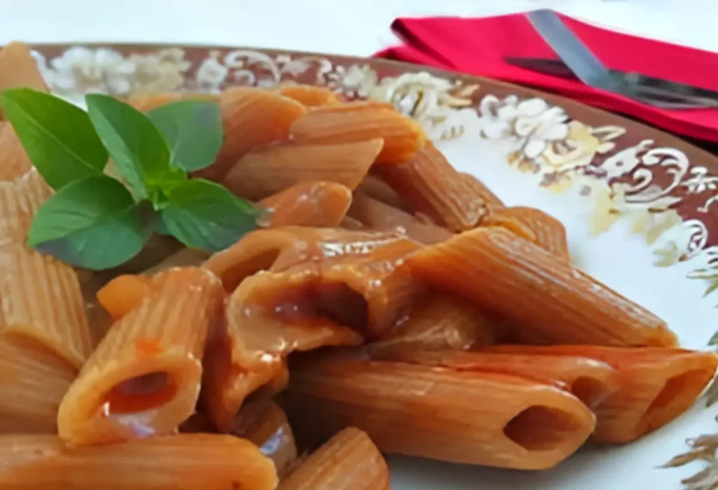 Um prato com macarrão penne pronto para ser servido. 