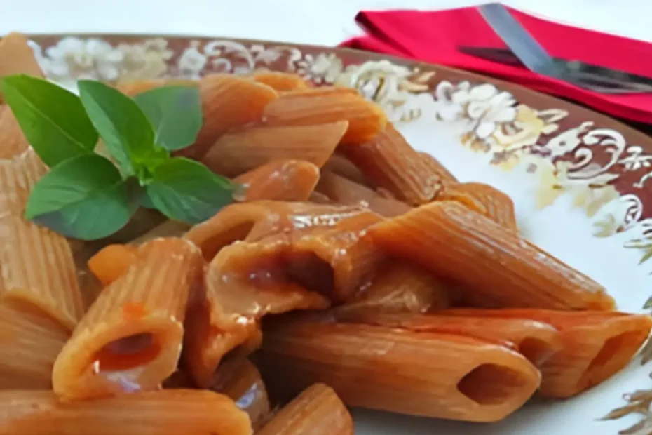 Um prato com macarrão penne pronto para ser servido.