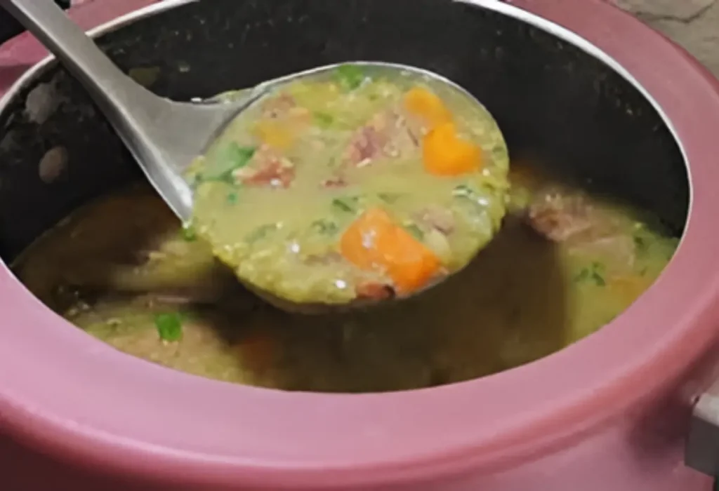 Uma panela de pressão com sopa de ervilha sendo preparada.