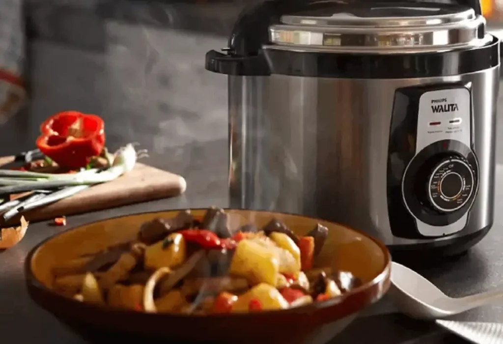 Uma panela elétrica de arroz em cima de uma mesa.