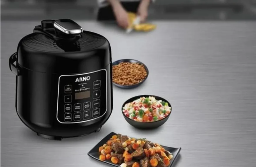 Uma panela elétrica de arroz em cima de uma mesa.