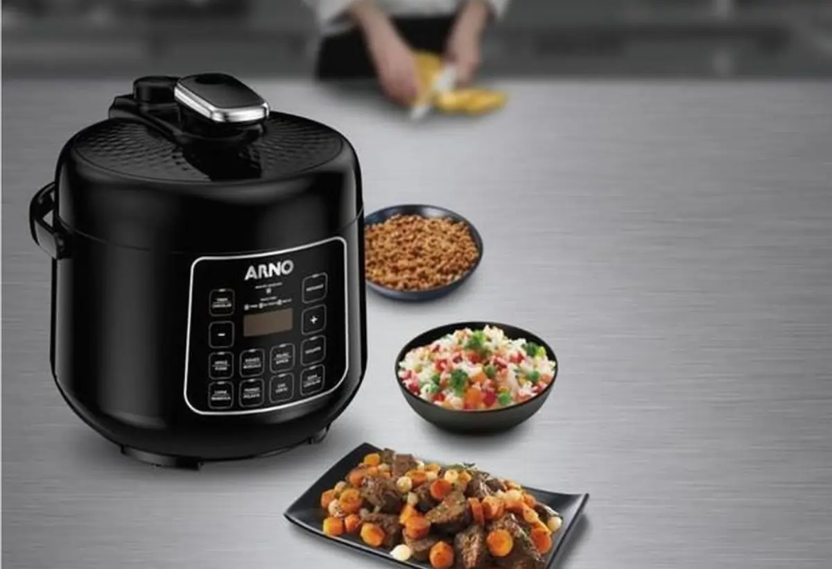 Uma panela elétrica de arroz em cima de uma mesa.