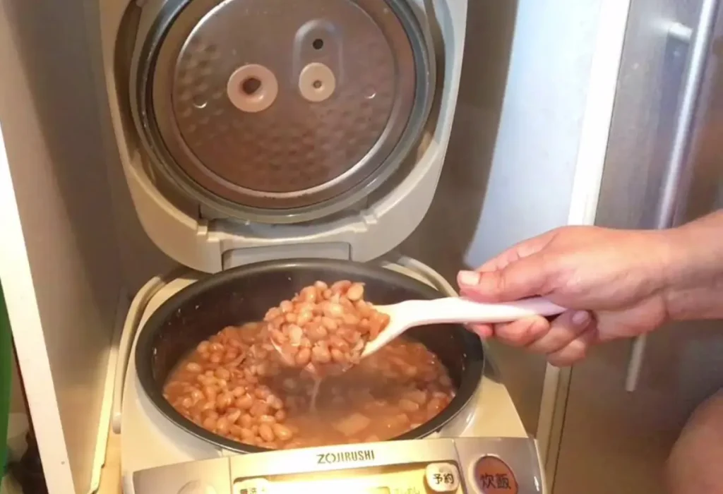 feijão sendo preparado em uma panela elétrica de arroz.