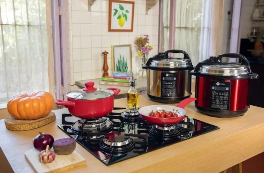 Uma bancada com fogão panelas convencionais e duas panelas elétricas de arroz.