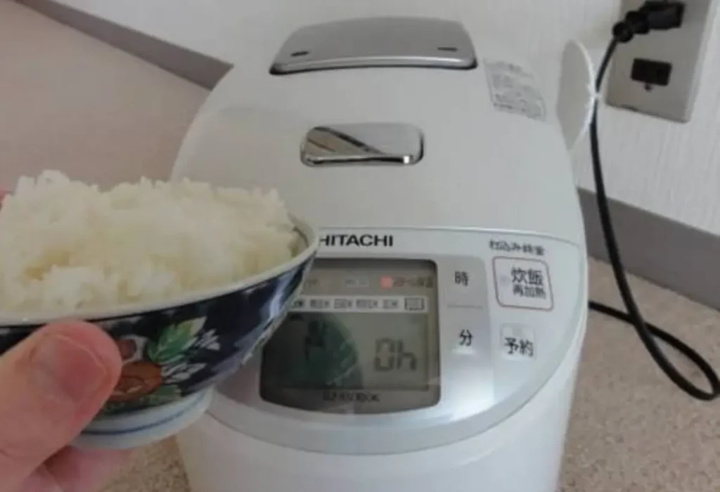 Arroz japonês sendo preparado em uma panela elétrica de arroz.