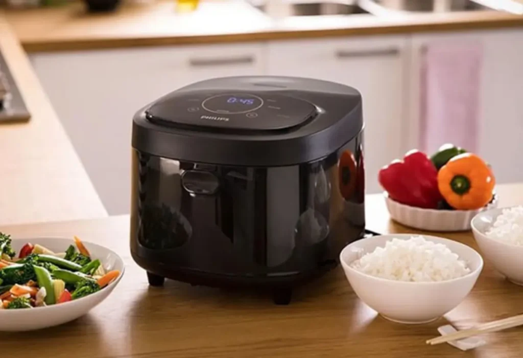 Uma panela elétrica de arroz em uma mesa.