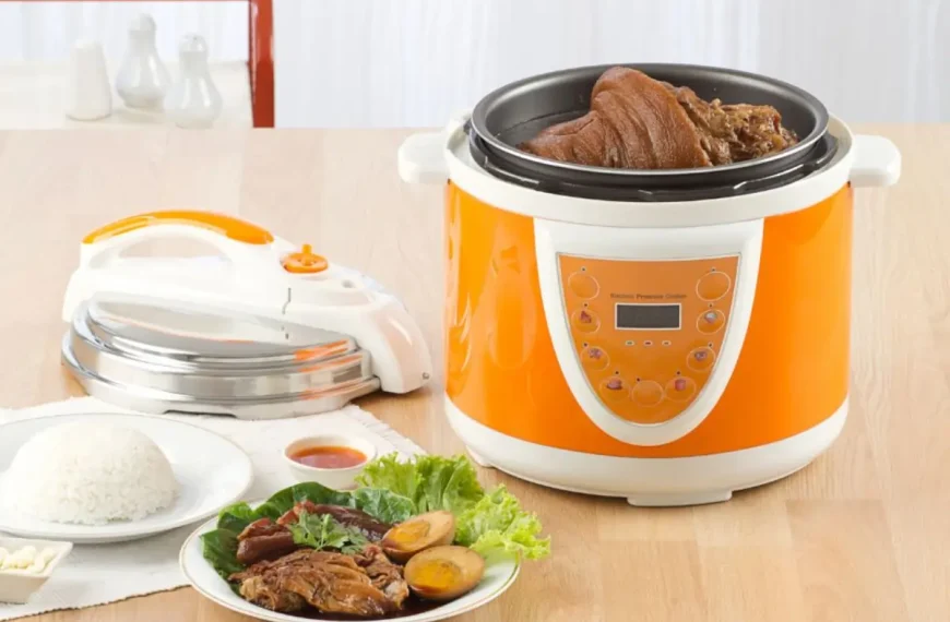 Panela de arroz elétrica em uma mesa com comidas para ser servida.