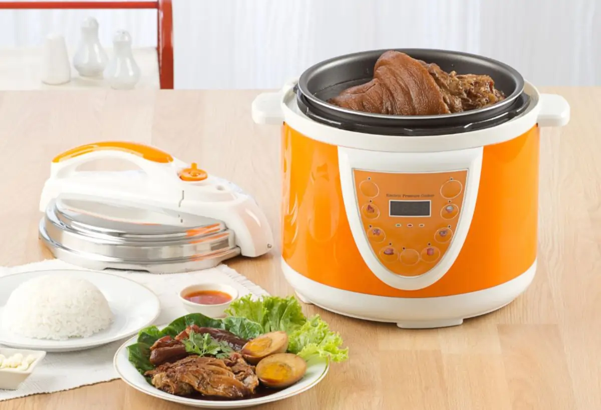 Panela de arroz elétrica em uma mesa com comidas para ser servida.
