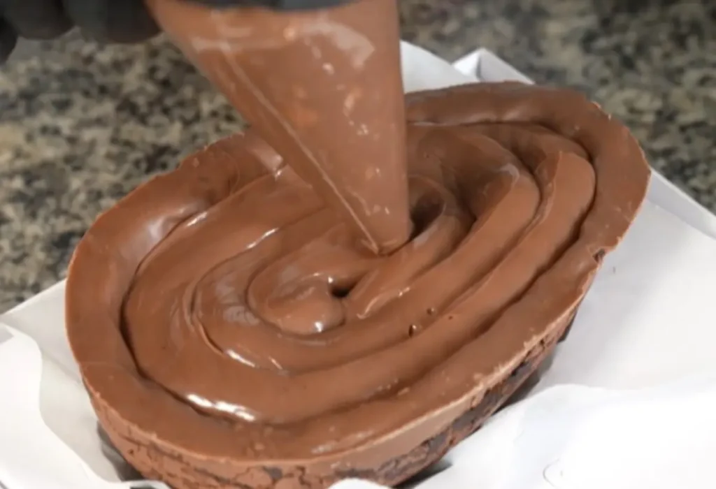 um ovo de pascoa sendo recheado.