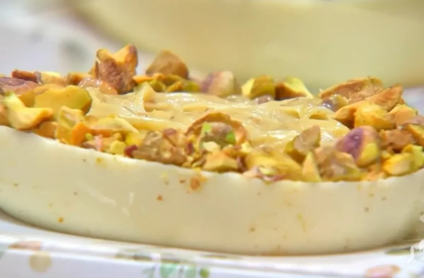 Meia casca de ovo de pascoa de chocolate branco com pistache pronto para ser servido.