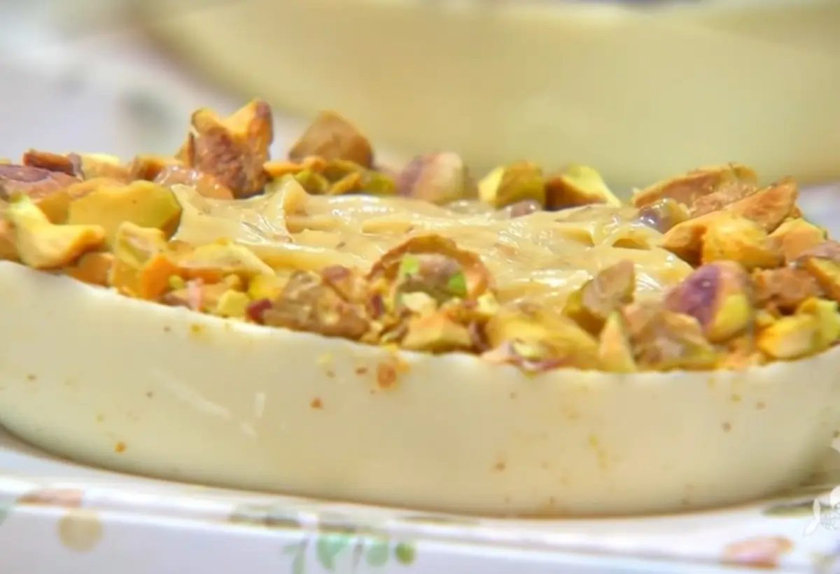 Meia casca de ovo de pascoa de chocolate branco com pistache pronto para ser servido.