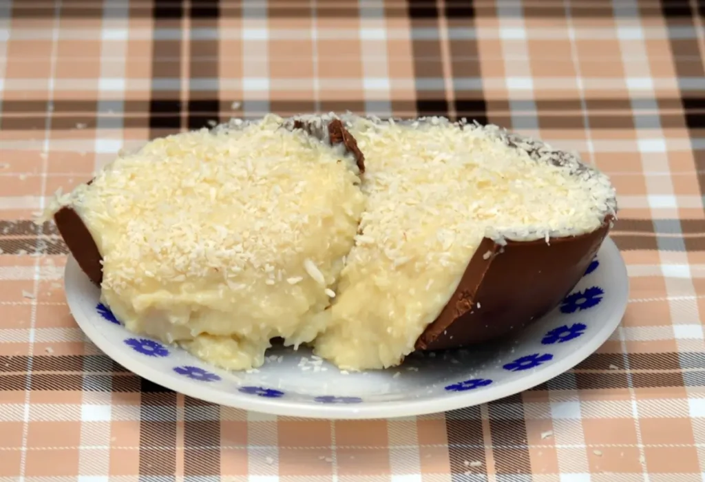 um prato com um ovo de páscoa recheado com beijinho.