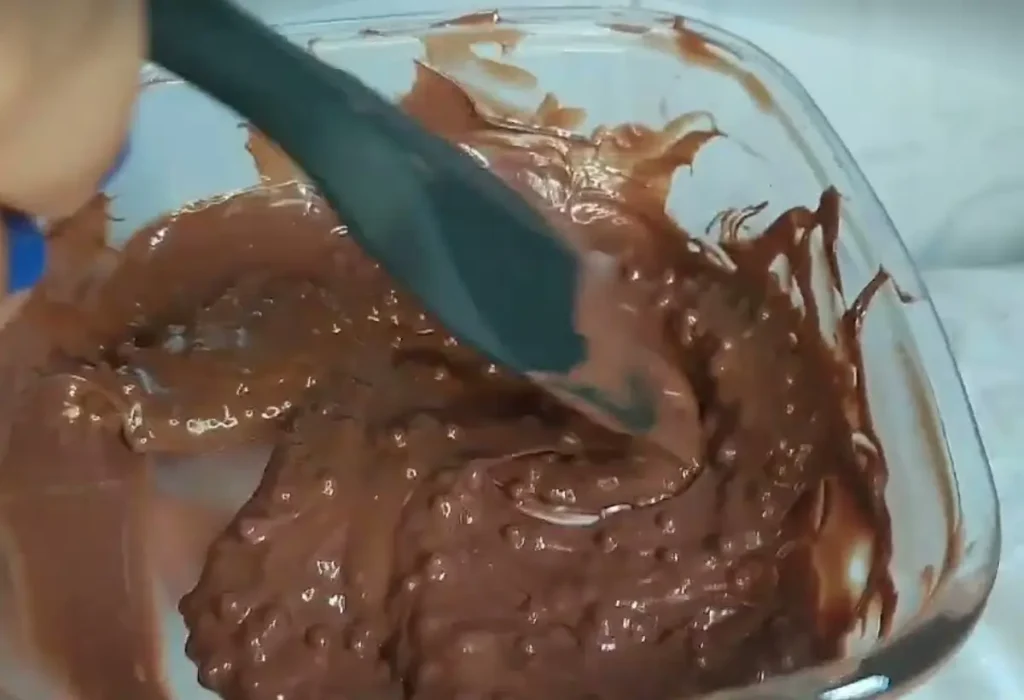 Uma travessa de vidro com mistura para ovo de pascoa crocante.