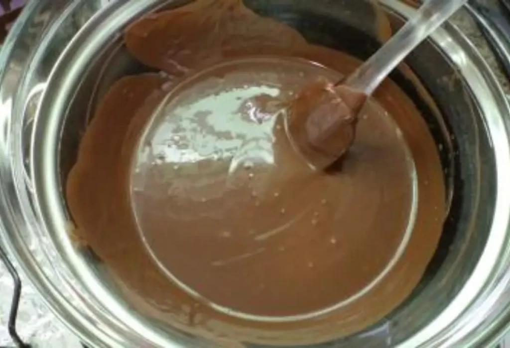 Uma tigela de vidro com chocolate sendo derretido.
