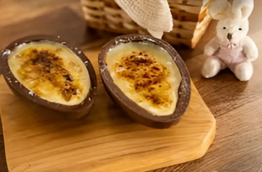 Uma mesa com decoração de páscoa e dois ovos recheados com creme de brulee.